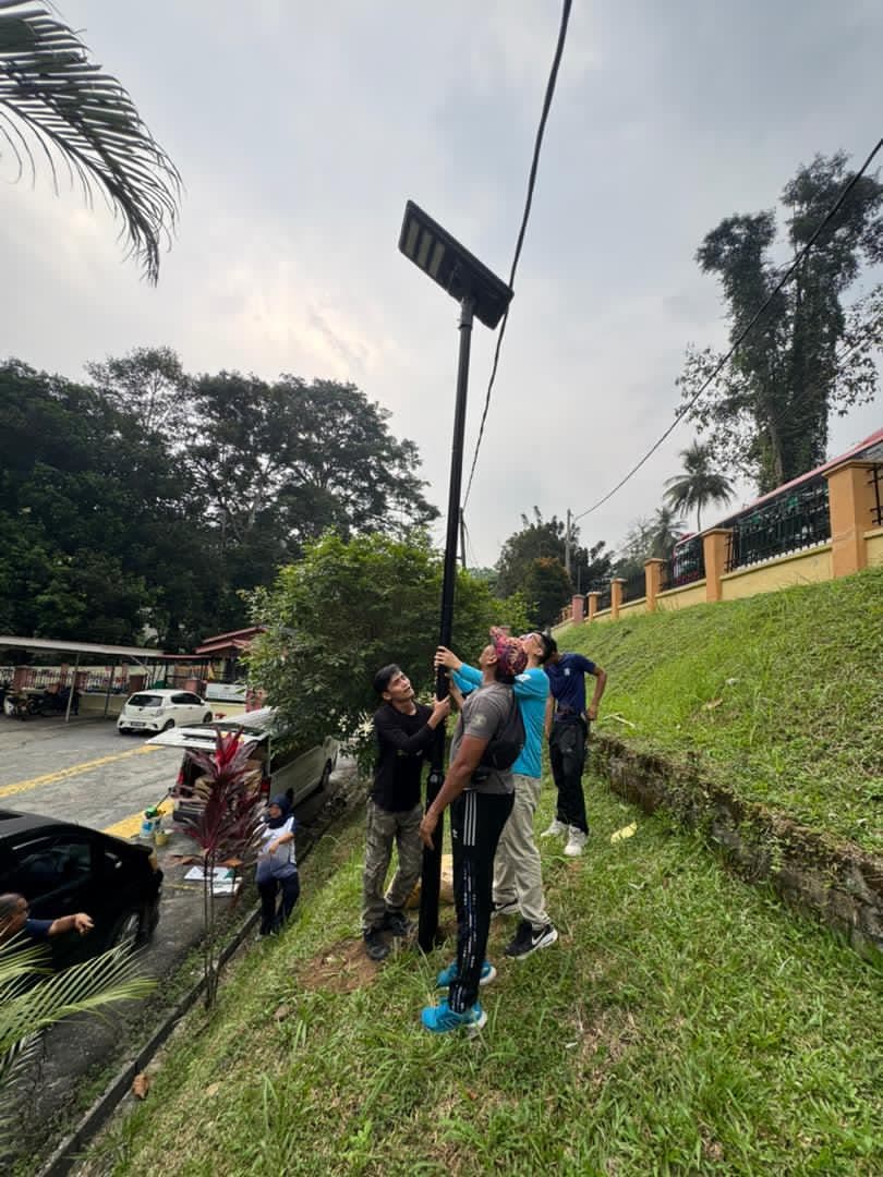 A team raising a solar street light pole on the slope