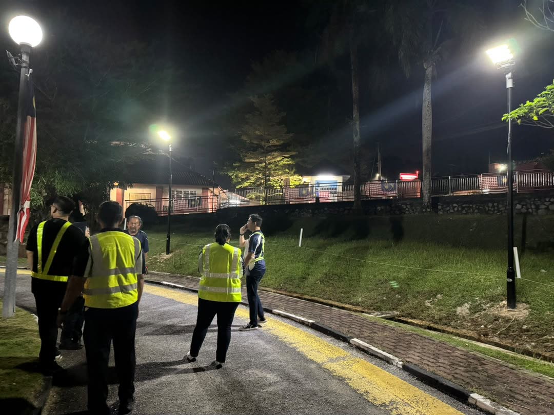 Solar street lights glowing along the hospital road at night as the team looks on